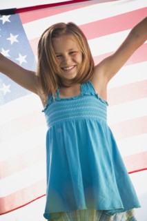 Young girl holding American flag. Photo : Mike Kemp