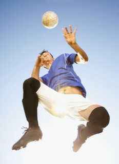 Soccer player heading the ball. Photo : Mike Kemp