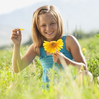 Young girl pulling petals off of gerbera daisy. Photo : Mike Kemp