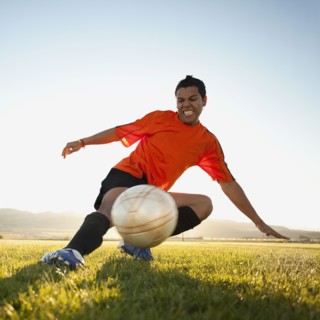 Soccer player kicking the ball. Photo : Mike Kemp