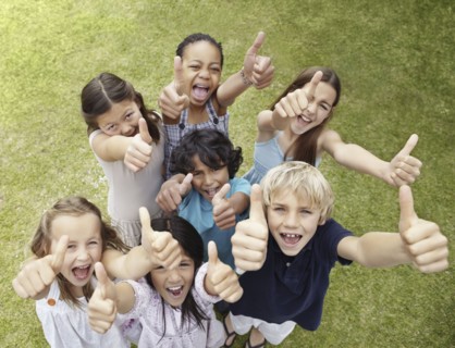 Group of children with their thumbs up. Photo : momentimages