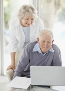 Senior couple browsing the internet together. Photo : momentimages