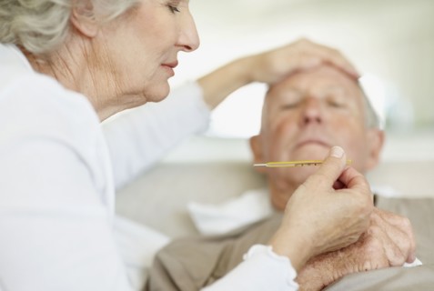 Senior woman caring for man with a fever. Photo : momentimages