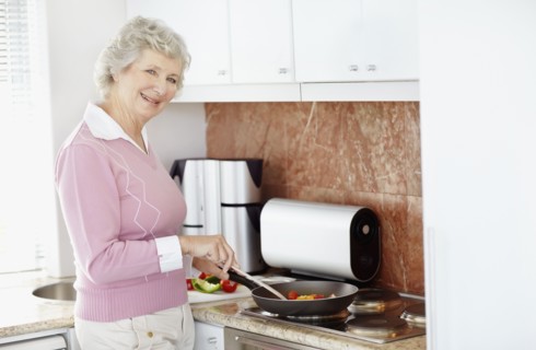 Senior woman cooking. Photo : momentimages