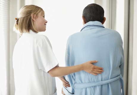 Nurse assisting patient with a walker. Photo : momentimages