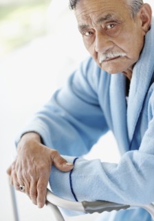 Elderly patient leaning on a walker. Photo : momentimages