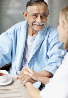 Nurse and senior patient sitting at table. Photo : momentimages