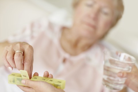 Nurse giving pill to senior woman. Photo : momentimages