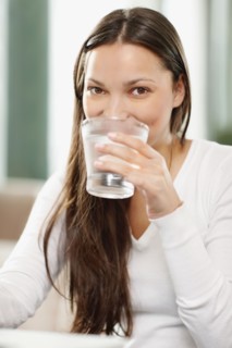 Woman drinking a glass of water. Photo. momentimages