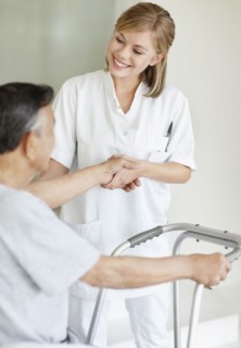 Nurse assisting patient with a walker. Photo : momentimages