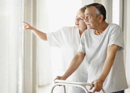 Nurse assisting patient with a walker. Photo : momentimages