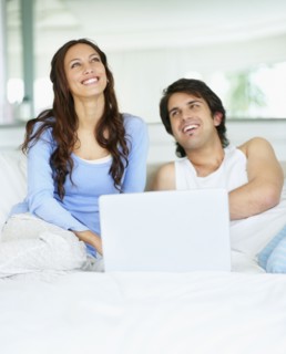 Couple looking at laptop together. Photo. momentimages