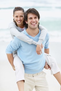 Man giving woman a piggy back ride. Photo : momentimages