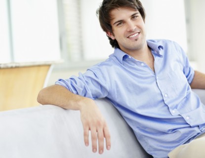 Handsome man sitting on couch. Photo : momentimages