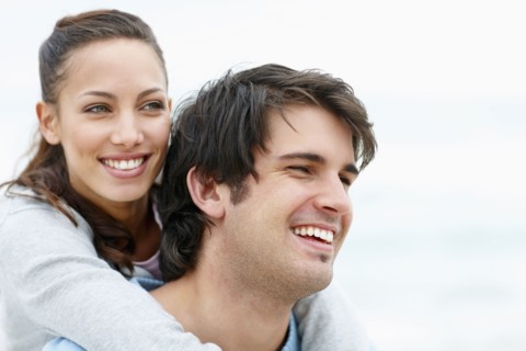 Man giving woman a piggy back ride. Photo : momentimages