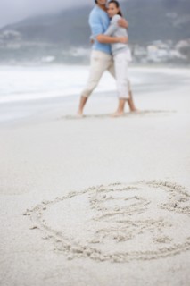 Couple embracing at the beach. Photo : momentimages