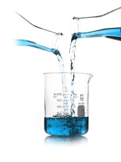 Blue liquid being poured into measuring cup. Photo : David Arky