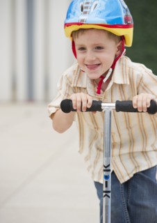 Young boy riding a scooter. Photo : Daniel Grill