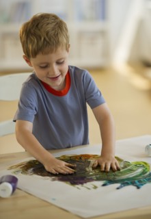 Young boy finger painting. Photo. Daniel Grill