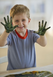Young boy finger painting. Photo. Daniel Grill