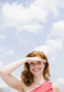 Beautiful woman shielding her eyes from the sun. Photo : Jamie Grill