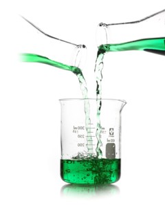 Green liquid being poured into measuring cup. Photo : David Arky