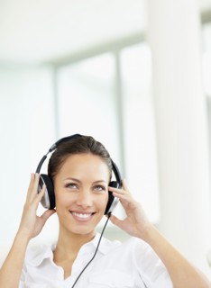Woman listening to music on headphones. Photo : momentimages