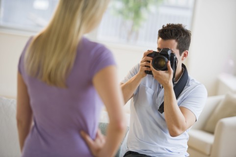 Man taking photograph of woman.