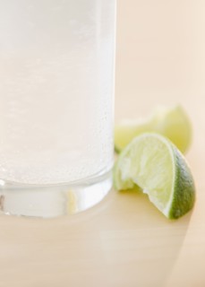 Slices of lime beside glass of water. Photo : Jamie Grill