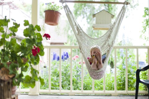 Young girl reading in hammock. Photo : Tim Pannell