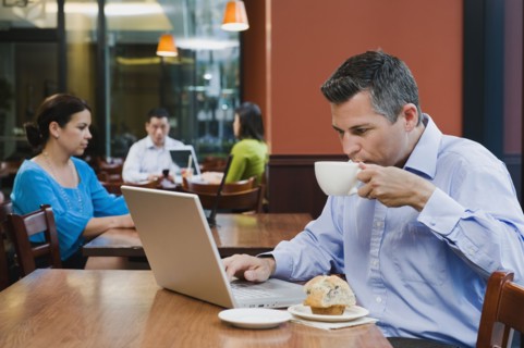 Man working on laptop in restaurant.