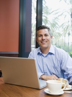 Man working on laptop in restaurant.