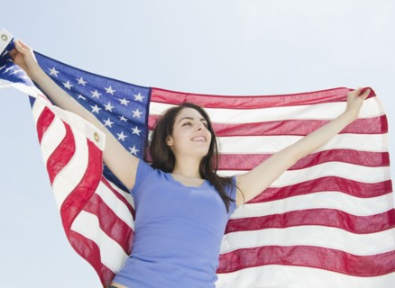 Woman holding American flag. Photo : Jamie Grill