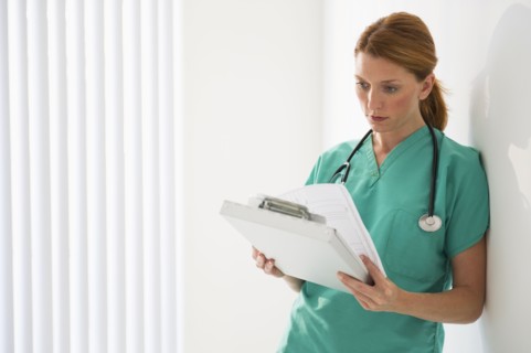 Healthcare worker looking at medical chart.