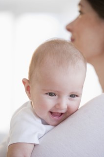 Baby being held by mother.