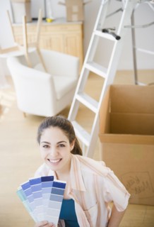 Woman holding paint swatches. Photo. Jamie Grill