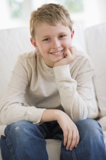 Young boy sitting on couch.