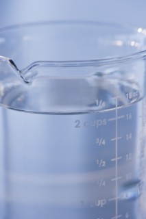 Measuring cup full of water. Photo. Daniel Grill
