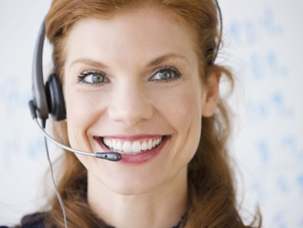 Cheerful businesswoman wearing headset. Photo : Jamie Grill