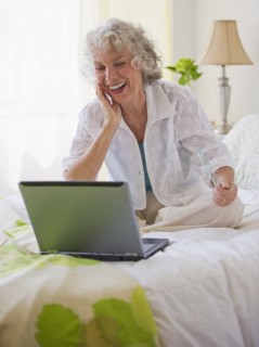 Cheerful woman looking at laptop. Photo : Daniel Grill