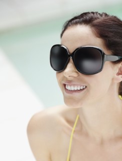 Brunette wearing large sunglasses. Photo. momentimages