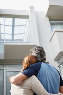 Couple looking at the their home. Photo : momentimages