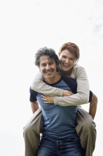Man giving woman a piggy back ride. Photo : momentimages