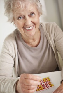Senior woman playing bingo. Photo : momentimages