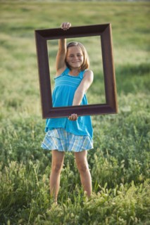 Young girl holding picture frame. Photo. Mike Kemp