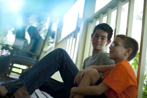 Two young boys sitting on porch. Photo : Tim Pannell