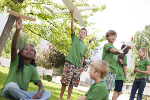 Group of children playing with toy airplanes. Photo : Tim Pannell