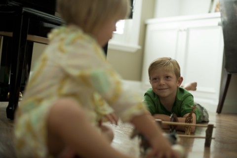Brother and sister playing with toy animals. Photo : Tim Pannell