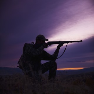Hunter pointing his rifle. Photo. Mike Kemp