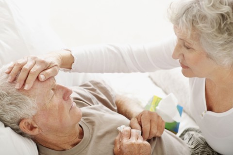 Senior woman caring for man with a fever. Photo : momentimages